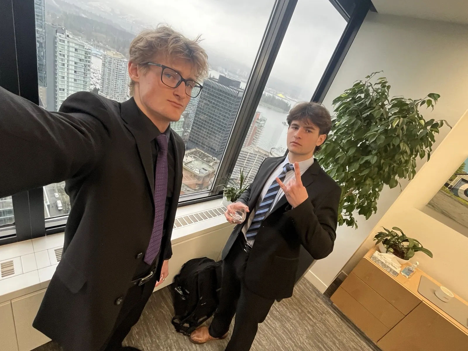 Zander Dent and a colleague in suits in a high-rise office overlooking the city