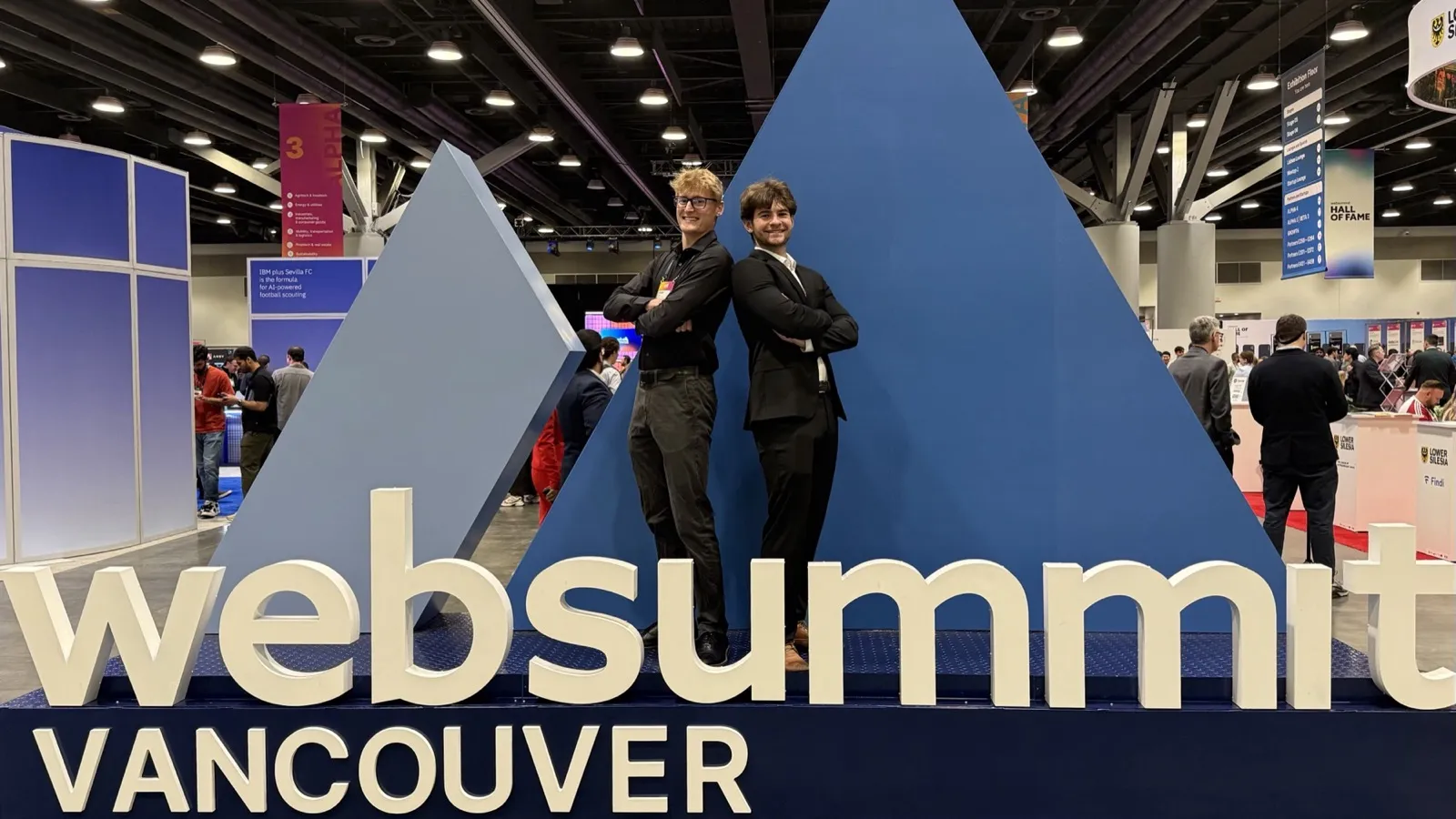Zander Dent and a colleague in front of the Web Summit Vancouver sign